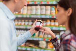 Coppia che legge l'etichetta di una marmellata da discount