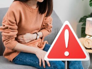 sfondo ragazza con mal di pancia e cartello con punto esclamativo