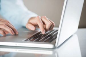 Persona che digita sulla tastiera di un portatile