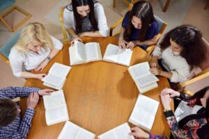 Ragazze intorno a un tavolo con un libro davanti