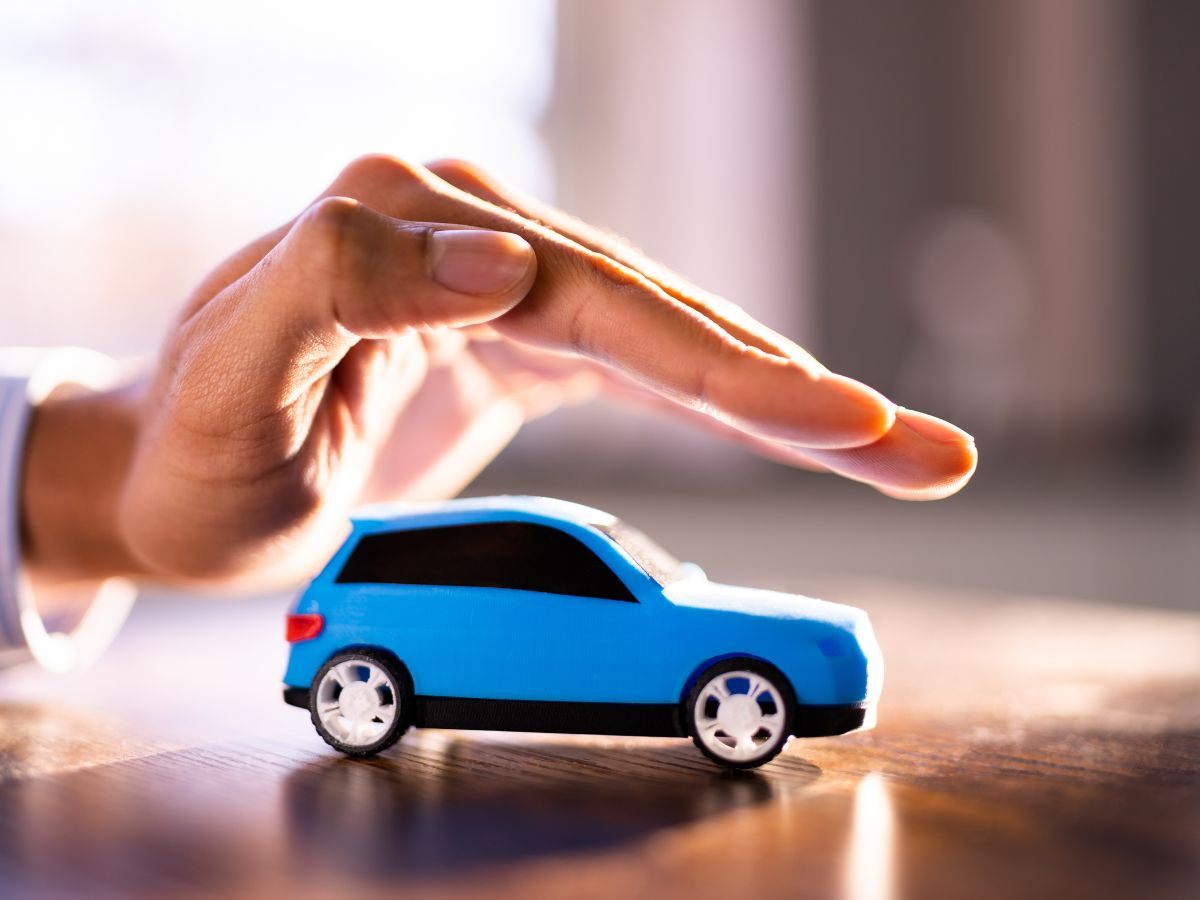 Mano che copre un modellino di auto