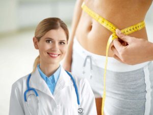 sfondo donna che tiene metro allo stomaco e nutrizionista