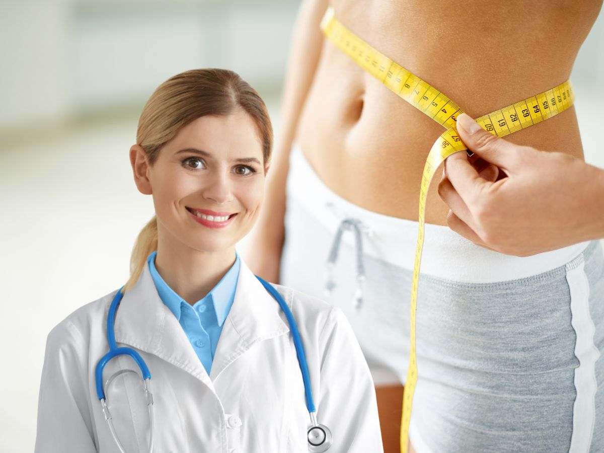 sfondo donna che tiene metro allo stomaco e nutrizionista