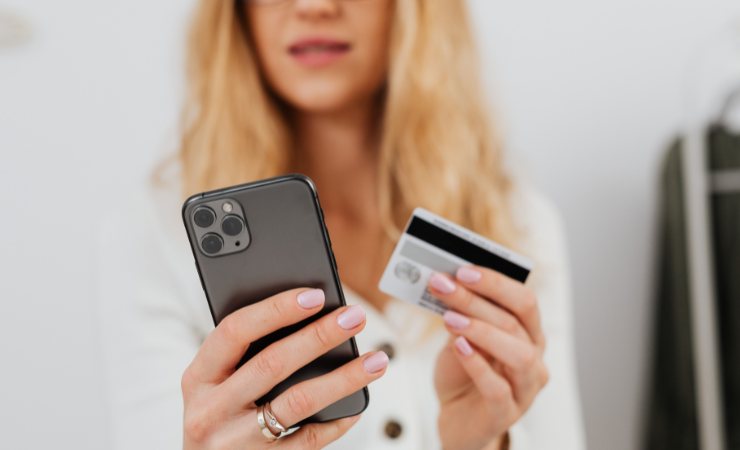persona con telefono e carta di credito