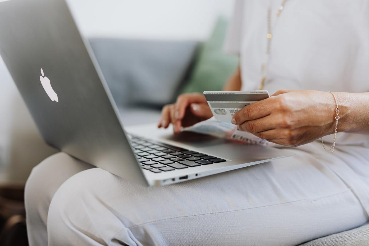 persona con computer, carta di credito