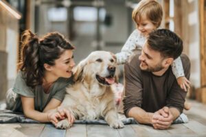 famiglia felice stesi per terra con un bambino e un cane