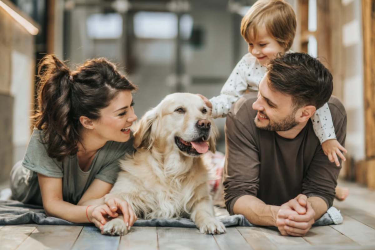 famiglia felice stesi per terra con un bambino e un cane