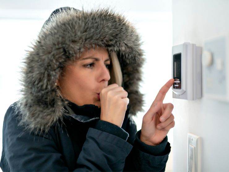 donna che sente fredde e che imposta termostato