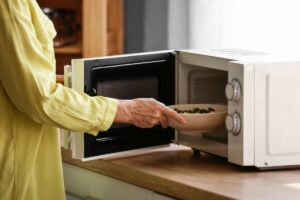 donna che mette piatto nel bollitore