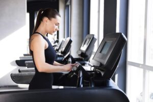 Donna che corre sul tapis roulant in palestra